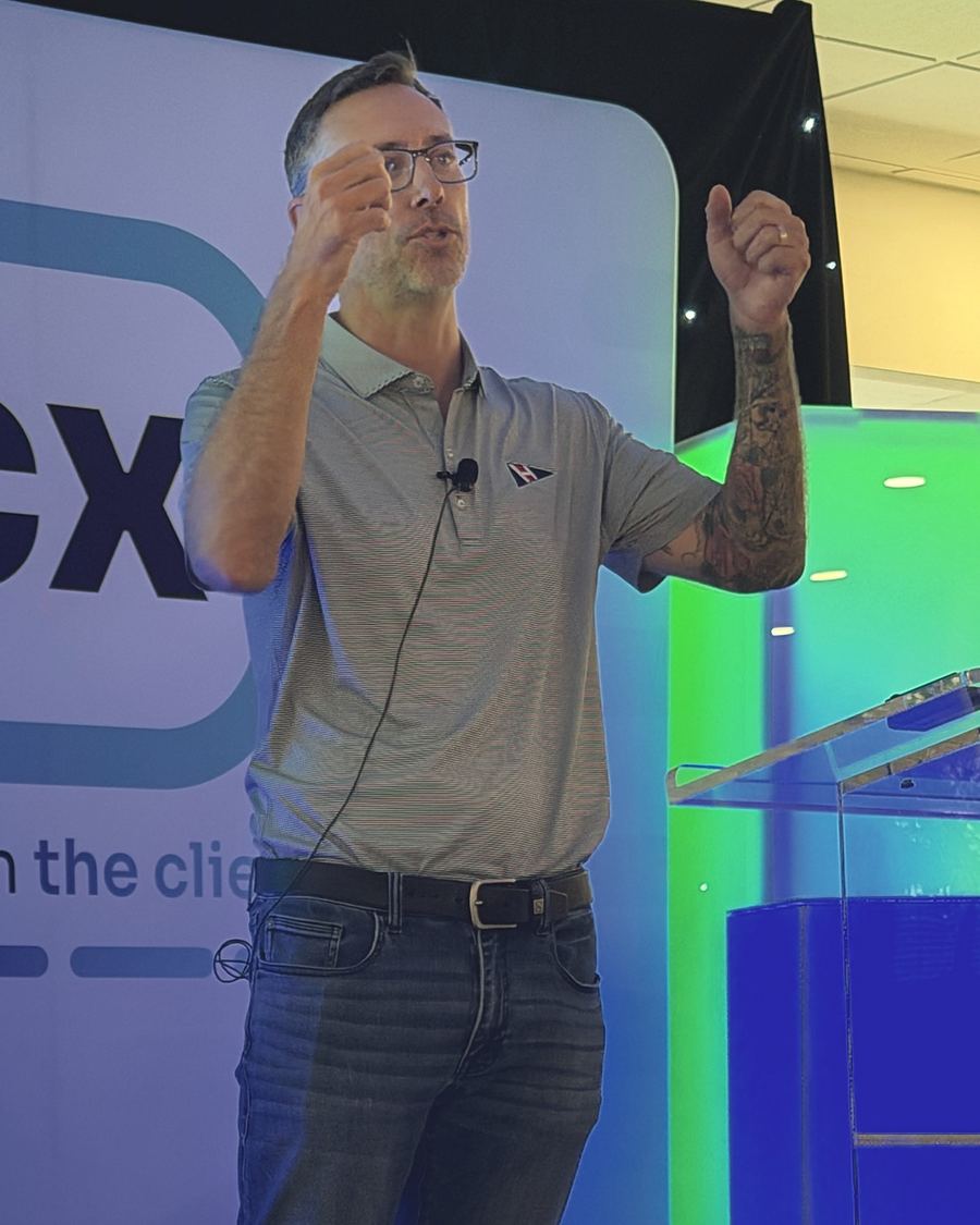 Travis Lee Howard mid-talk, gesturing to the room